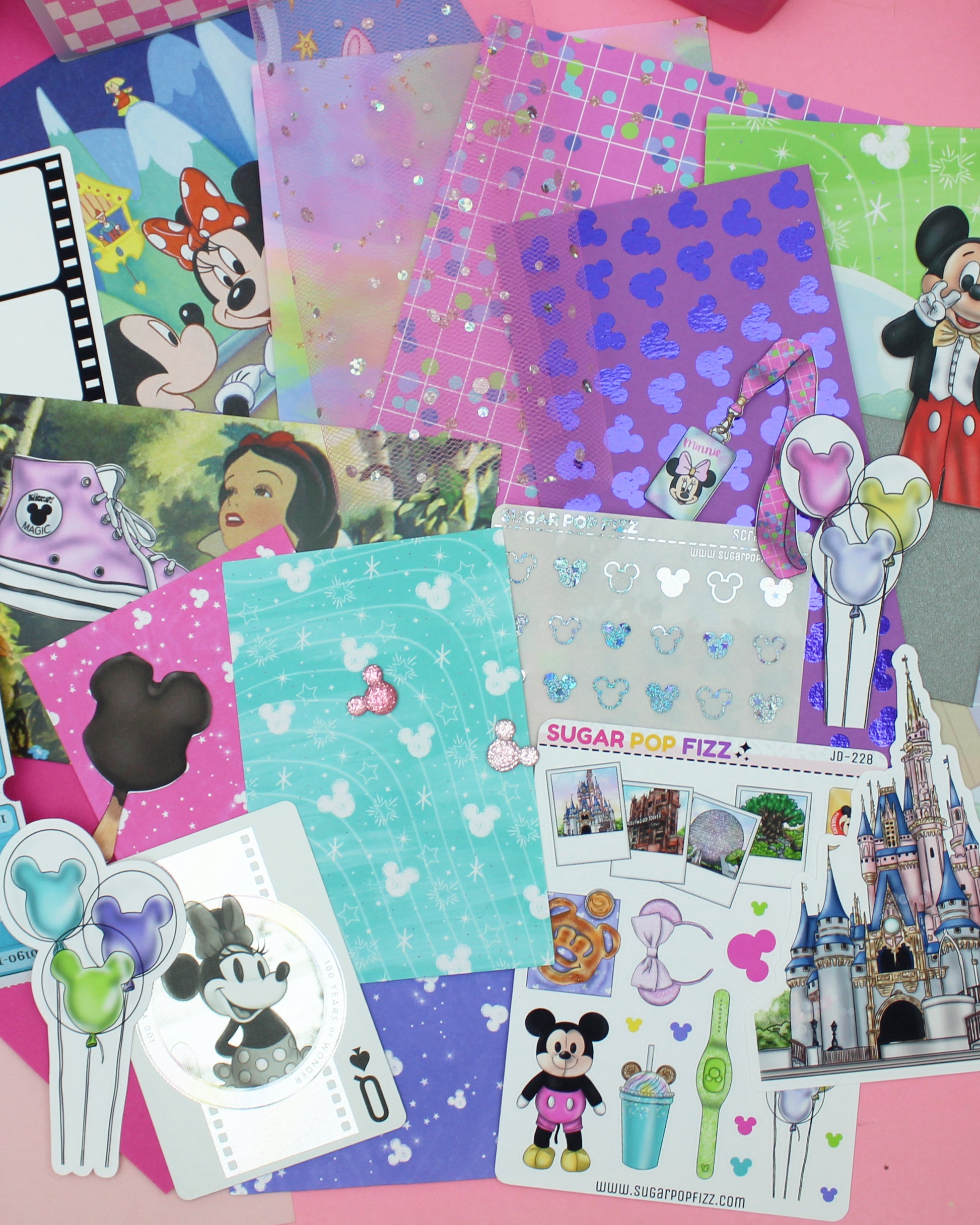 Collection of Disney-themed stickers and paper on a pink background