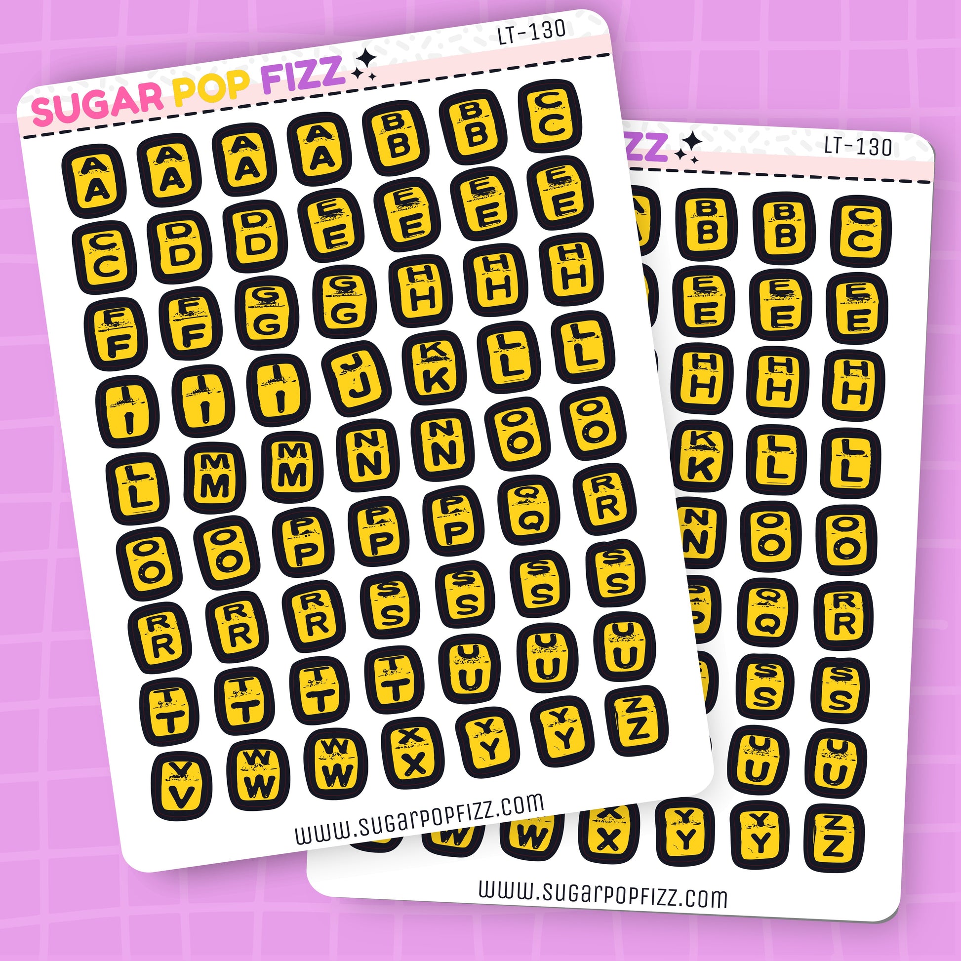 Two sheets of letter and number stickers with yellow and black design on a purple grid background.