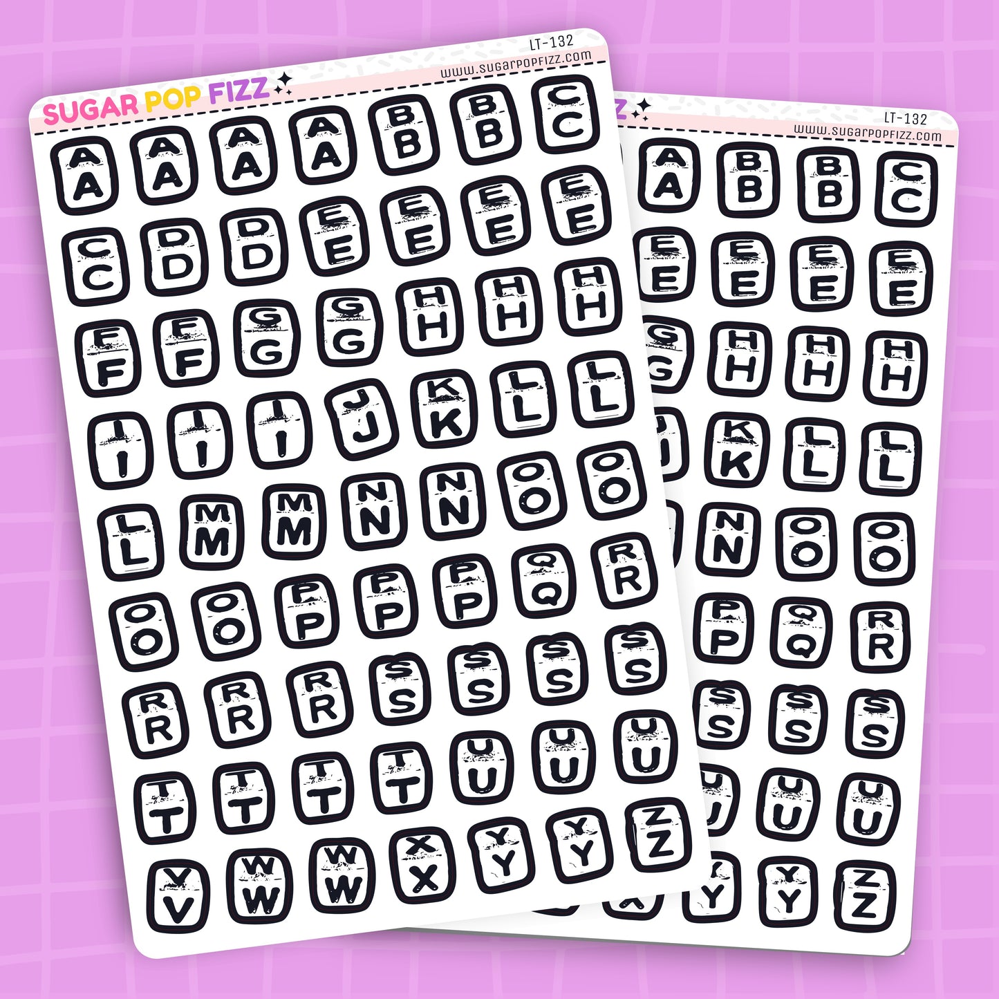 Two sheets of black letter stickers on a purple background
