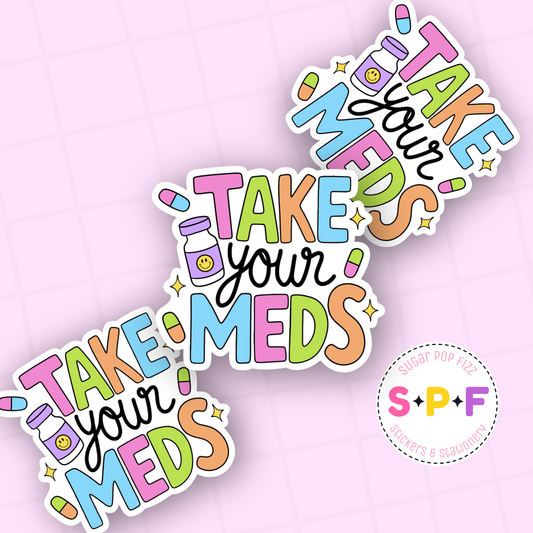 Colorful 'Take Your Meds' stickers on a pink background with a visible brand logo.